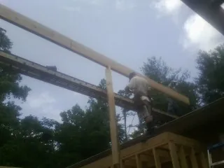 Carpenter setting a ridge beam over a new addition frame — Ice Dam Removal by Roofing Brothers in West Des Moines