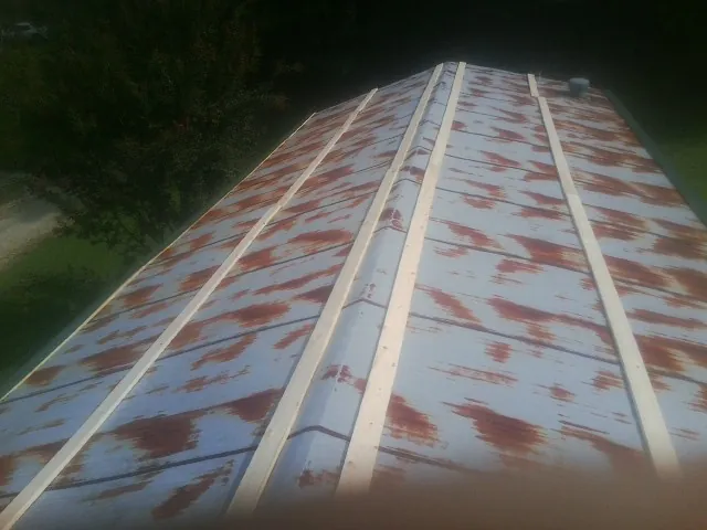 Rusted metal roof panels with new wood purlins before replacement — Storm Damage Roof Repair in West Des Moines by Roofing Brothers