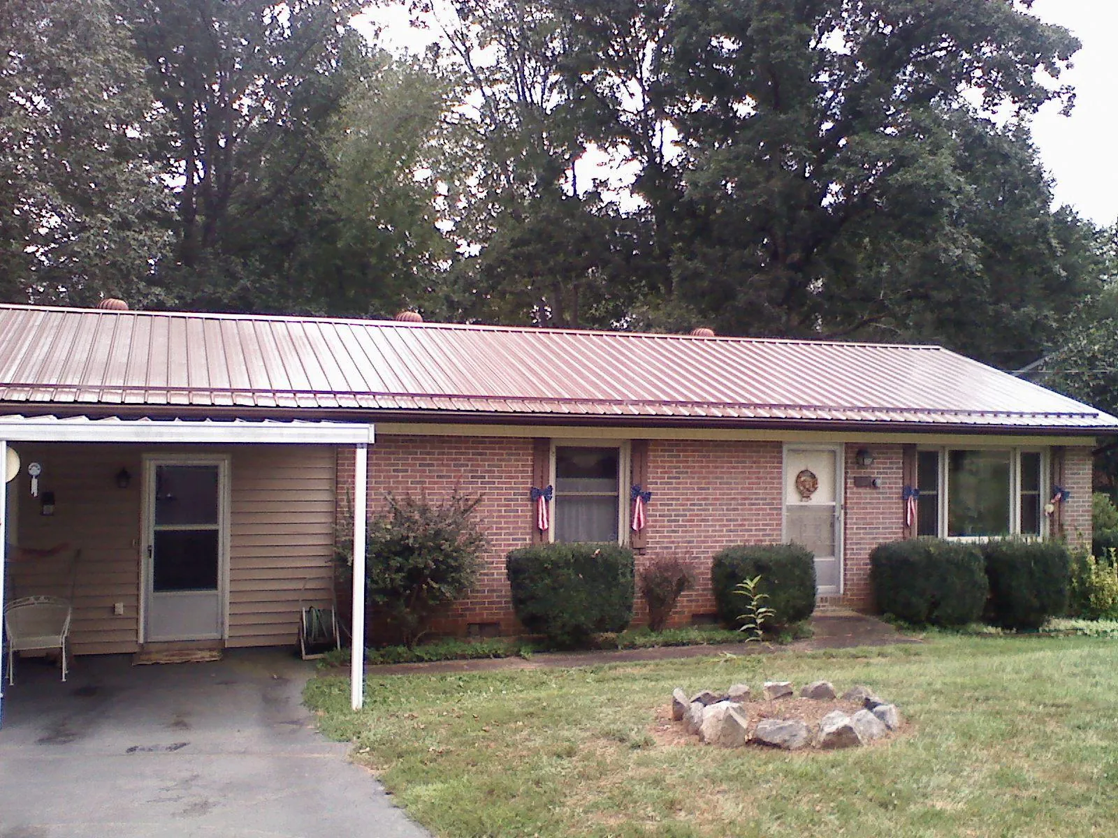 Bronze metal roof and carport on a brick ranch home — Roof Repair work by our crew in West Des Moines