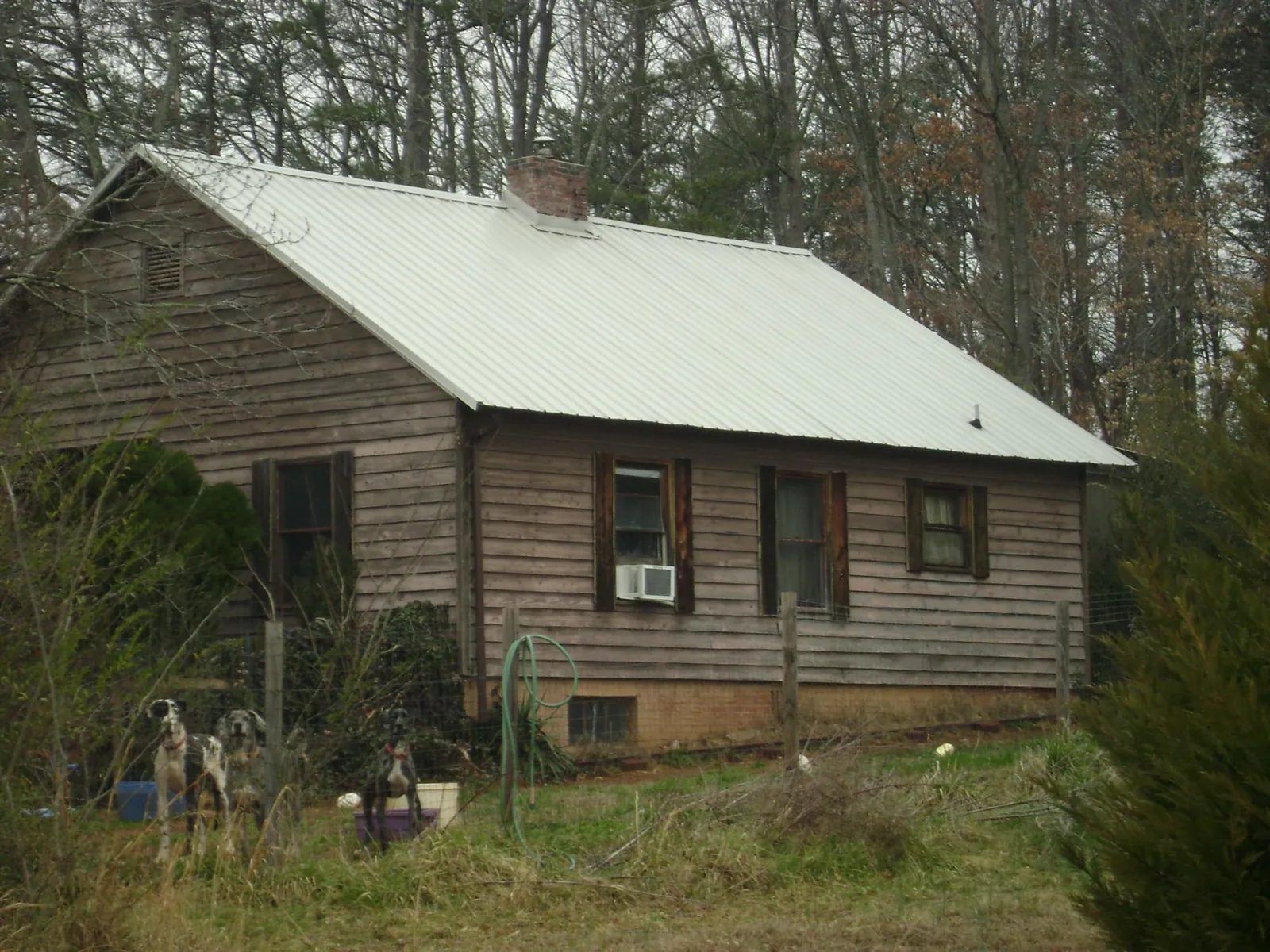 White metal roof on an old wood sided farmhouse, from a Metal Roof Installation job in West Des Moines